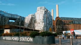 A View Of Battersea Power Station And People Strolling Along The Pavement