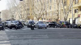 Motorists stopped at an intersection let an ambulance pass with its sirens blaring as it speeds through the intersection during an emergency in Rome.