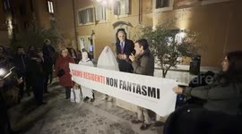 Two protesters dressed as ghosts behind the banner with the slogan ‘we are residents not ghosts’ displayed during the speeches during the protest against the unlivability of some areas of the historic center, due to mass tourism, in Rome.