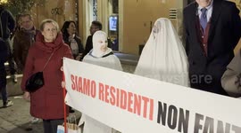Two protesters dressed as ghosts behind the banner with the slogan ‘we are residents not ghosts’ displayed during the speeches during the protest against the unlivability of some areas of the historic center, due to mass tourism, in Rome.