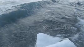 limpid waves pitch the shore making bubbles and foam. The water is steaming.