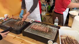 At a stand selling Chinese food, people of Chinese origin grill skewers and fry other dishes during the Chinese New Year celebrations in Rome.