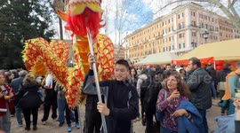 Chinese boys slither a large representation of a snake among the crowd in the gardens of Piazza Vittorio during the Chinese New Year celebrations in Rome.
