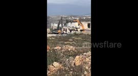 Israeli forces' bulldozers knock down a house in the village of Deir Ibzi', west of Ramallah