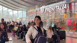 Travelers in the waiting zone on a day when the incoming train board shows heavy delays of up to more than 3 hours at Termini Station in Rome.