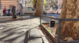 A keybox, one of the symbols of overtourism, hanging from a fence bar of a tree in Rome.