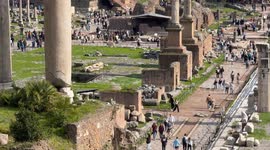 Vertical movement overview of the Roman Forum visited by many tourists on a day with spring temperatures in February in Rome.