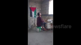 A Palestinian man from Gaza uses empty buckets as drums while singing for Palestine