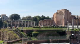 Overall view of the ruins of the Temple of Venus with tourists with horizontal movement up to the frame of the Basilica of Santa Francesca Romana on a clear Sunday in February with spring temperatures in Rome.