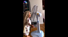 Child interacts with running fan in Bangkok, Thailand