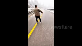 Local uses bamboo slates to glide effortlessly down icy road in China