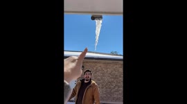 Friends play with an icicle from the roof in Louisiana, USA