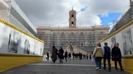 People come and go in Piazza del Campidoglio during the renovation of the facades of the buildings in the square on a day with a slightly overcast sky in Rome.