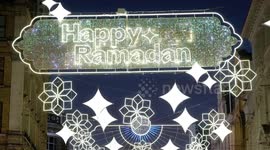 Crescent moon is seen behind Ramadan Lights in London's West End
