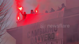 Protesters on the roofs of a building with red smoke bombs hang a large banner with the motto ‘let's really change Quarticciolo’ in the rain during during the demonstration to ask for the planning of structural interventions for Quarticciolo in Rome.
