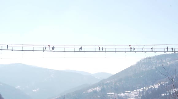 People walking over Blackforestline in Todtnau on a sunny winter day.