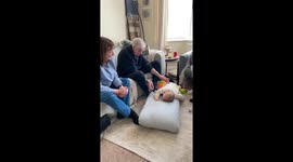 Mother rests with Do Not Disturb sign as grandparents entertain baby in Stoke-on-Trent, UK