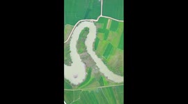 Curved stream winds through rice fields in S China