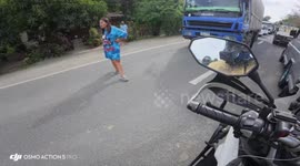 Woman sings and dances in the middle of the road, causing traffic in Quezon, Philippines