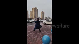 Security guard dances to cheer up child waiting for mother at nursery gate in adorable footage