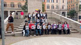Some protesters improvise a flash mob displaying an Ecuadorian flag and placards that spell out the phrase 'Sacha se defiende' in Rome.