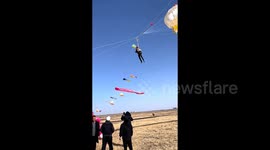 Man hoisted into sky by kite and casually takes video in mid-air