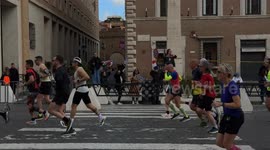 French spectators cheer as they wave flags as runners pass by on Via della Conciliazione during the Acea Run Rome The Marathon in Rome.