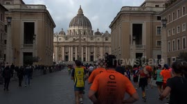 Runners arrive at St. Peter's Square as St. Peter's Basilica in the background gradually lights up with sunlight during the Acea Run Rome The Marathon in Rome.