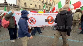 Protesters hold up a banner with the slogans 'Rulers, if you want war, pay and fight yourself!' and 'no war' in Italian and English while waving Italian flags during the demonstration entitled ‘Peace and sovereignty’ promoted by the leaders of Democrazia 