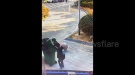 Woman pushing tall bin fails to spot stone bollard and doesn't realise it's stuck