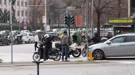 A man sells bunches of mimosa flowers at a crossroads on the occasion of Women's Day in Rome.