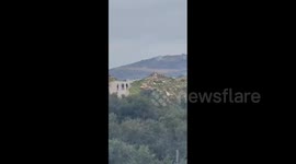 Armed Israeli settlers are seen walking with rifles near the towns of Aqraba and Majdal Bani Fadel