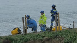 A positive outcome to a cliff top event, Coastguards persuade a casualty to come to safety. Barrowfields, Newquay, Cornwall, UK