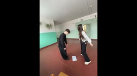 Person spins holding paper and falls after placing it down in Severodvinsk