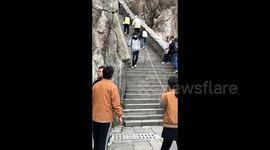 China: Sliding Downstairs on Feet on a Mountain Path