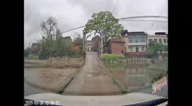 Driver navigates narrow road with water on both sides in Hunan, China