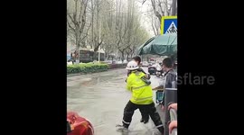 Chinese traffic officer carries students across flooded street