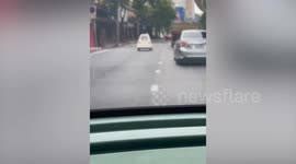 Tiny one-seater toy car drives along road in Bangkok