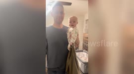 Mischievous baby grins with pride after stealing dad's shirt