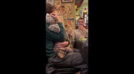 Brothers fighting over holding a cute baby.