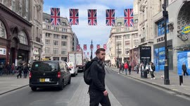 Oxford Street London union jack flags red busses taxis driving by