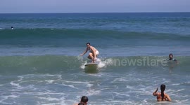 Beginner surfer crashes into a man on the beach