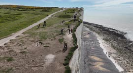 Visitors to Birling Gap walk close to the edge of the crumbling cliffs