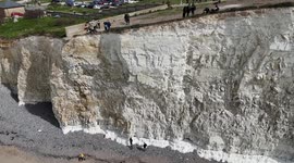Vistors to Birling Gap, UK  walk close to the edge of the crumbling cliffs