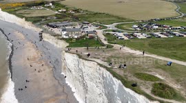 Vistors to Birling Gap, UK  walk close to the edge of the crumbling cliffs