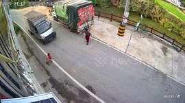Terrifying moment young girl is almost run over by speeding truck in China