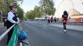Police help a runner get a good photo at the London Marathon