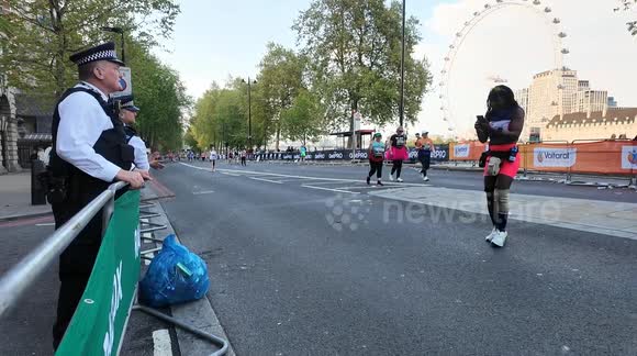 Police help a runner get a good photo at the London Marathon