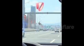 Wayward paraglider lands in middle of traffic on busy highway in China