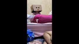 Child wears cardboard with cut-out lips and eyes in video